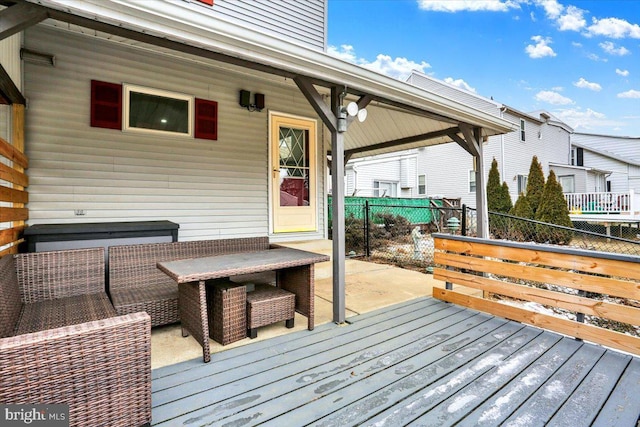 wooden terrace with an outdoor hangout area and fence