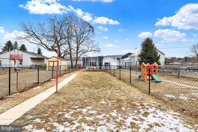 view of yard featuring a residential view, playground community, and fence