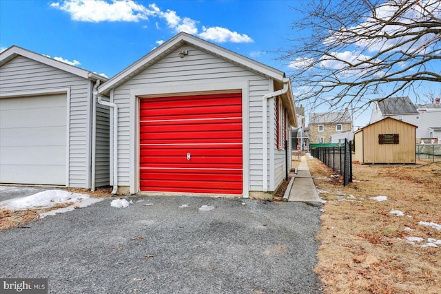 detached garage with a shed and fence