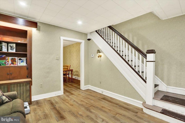 stairway with baseboards and wood finished floors