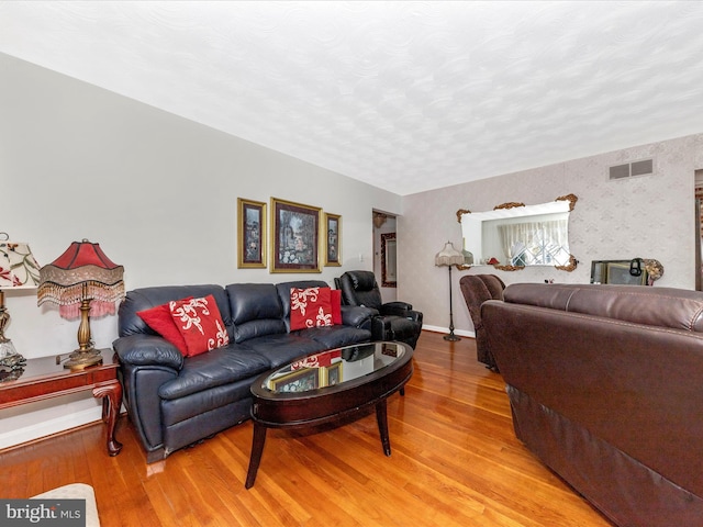 living room with light wood-type flooring and a textured ceiling