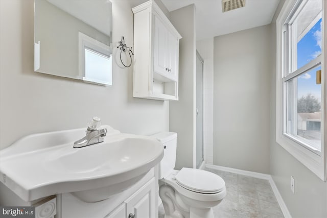 bathroom with baseboards, visible vents, toilet, a shower with shower door, and vanity