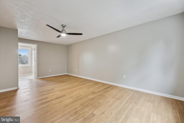 unfurnished room featuring ceiling fan, light wood finished floors, and baseboards