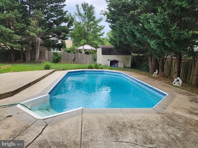 view of pool with a storage shed, an outbuilding, a fenced backyard, and a fenced in pool