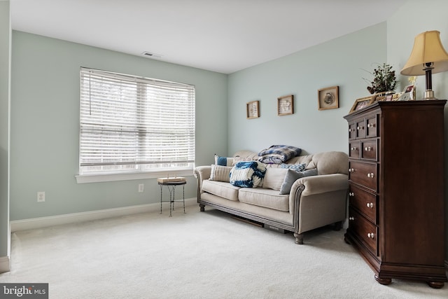 sitting room with light colored carpet, visible vents, and baseboards