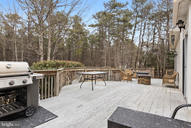 deck with a grill and a fire pit