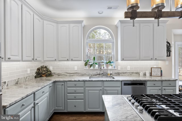 kitchen featuring visible vents, a sink, stainless steel appliances, white cabinetry, and backsplash