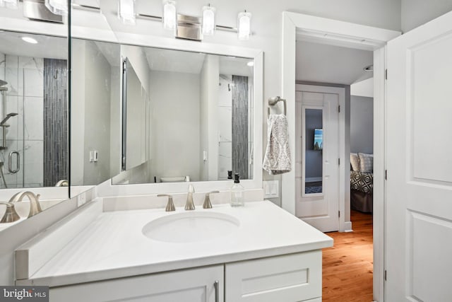 full bath with vanity, a stall shower, wood finished floors, and toilet