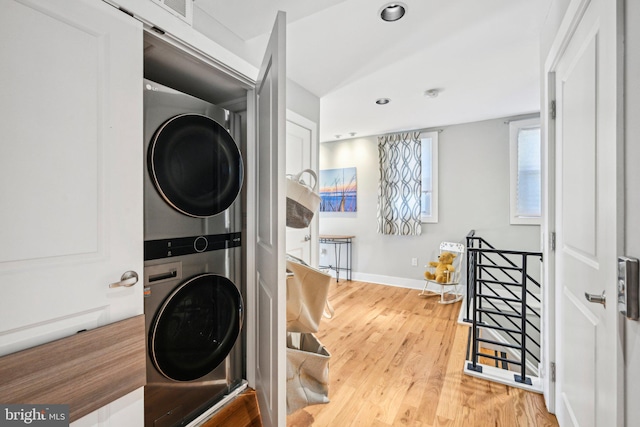 washroom with laundry area, baseboards, stacked washer and clothes dryer, wood finished floors, and recessed lighting