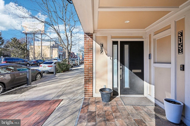 doorway to property featuring brick siding