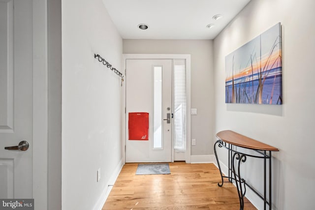 foyer with light wood-style flooring and baseboards