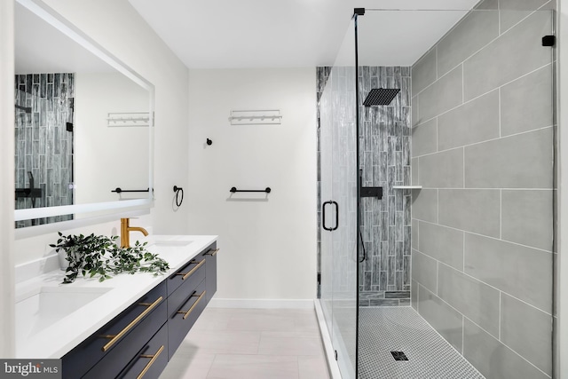 bathroom featuring double vanity, a shower stall, baseboards, and a sink