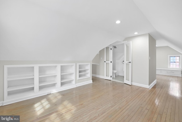 bonus room with baseboards, built in features, lofted ceiling, light wood-type flooring, and recessed lighting