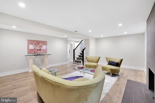 living area with baseboards, stairway, light wood-type flooring, and recessed lighting