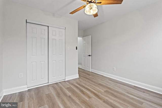 unfurnished bedroom with a closet, baseboards, light wood-style floors, and ceiling fan