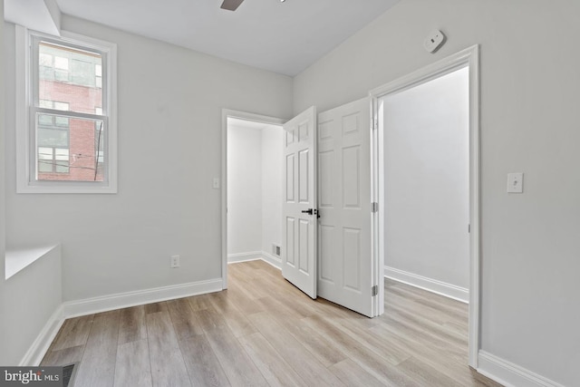 unfurnished bedroom with light wood-type flooring, baseboards, visible vents, and a ceiling fan