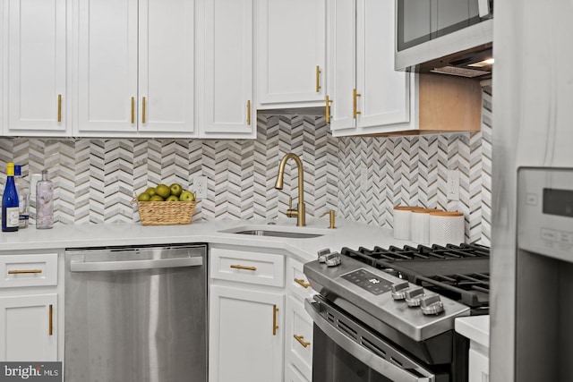 kitchen with a sink, appliances with stainless steel finishes, white cabinets, and light countertops