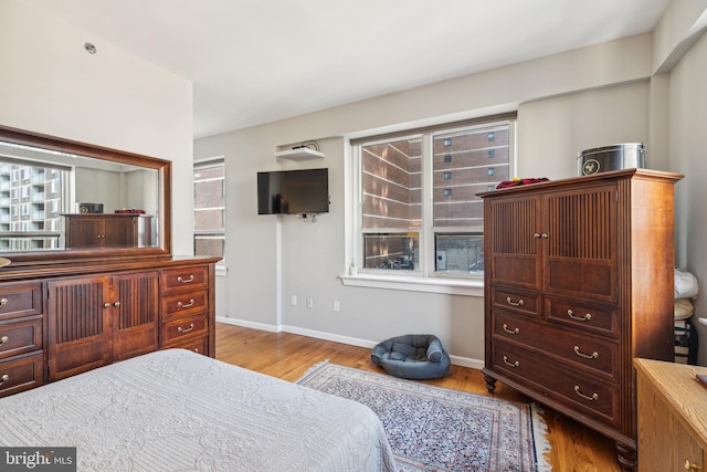 bedroom featuring baseboards and light wood finished floors