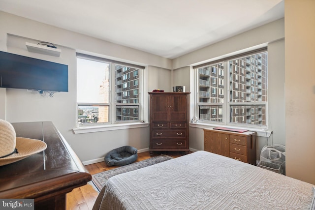 bedroom featuring wood finished floors and baseboards