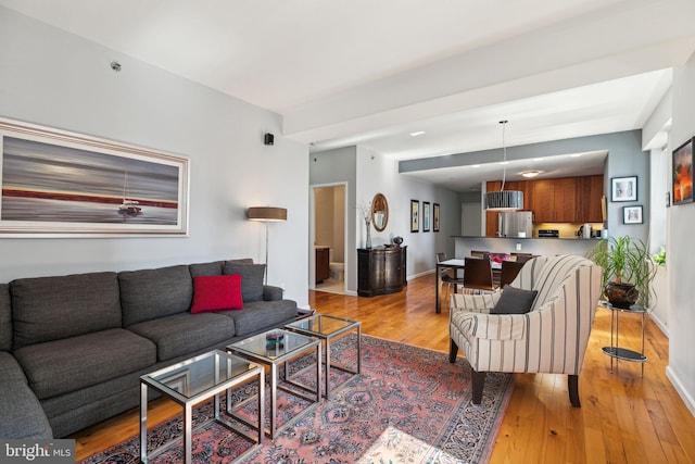 living area with light wood-type flooring and baseboards