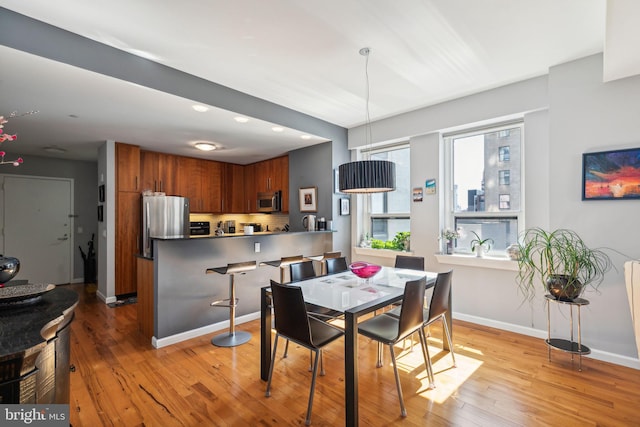 dining room featuring recessed lighting, baseboards, and light wood finished floors