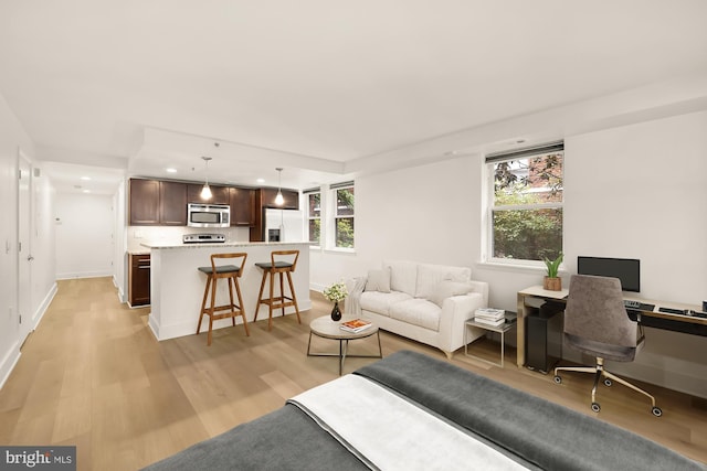 living area featuring light wood-style floors, baseboards, and recessed lighting