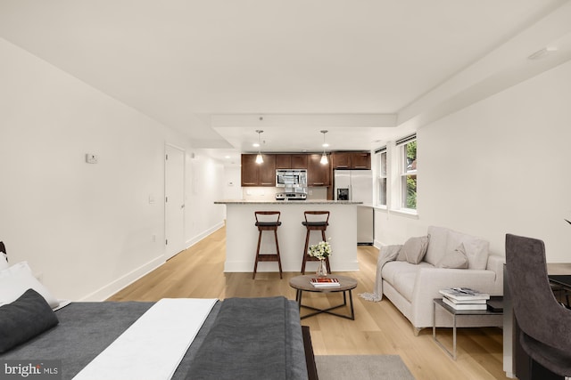 living area featuring light wood finished floors and baseboards