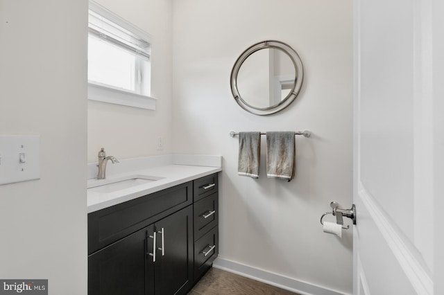 bathroom featuring vanity, baseboards, and wood finished floors