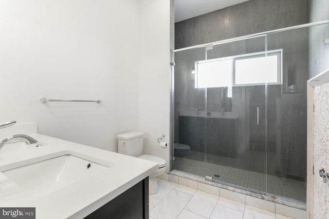 bathroom featuring marble finish floor, toilet, a shower stall, and vanity