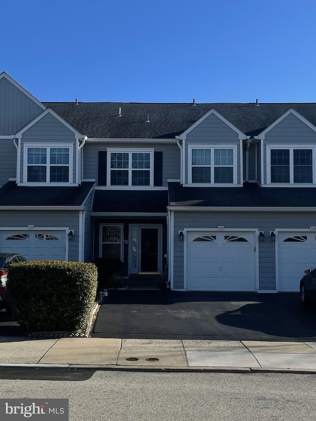 view of property with a garage and driveway