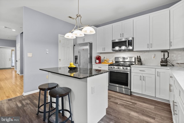 kitchen featuring white cabinetry, visible vents, appliances with stainless steel finishes, and a center island