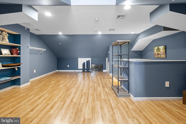 additional living space with built in shelves, light wood-style flooring, visible vents, and baseboards