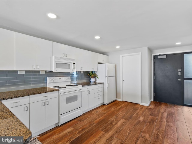 kitchen featuring backsplash, white appliances, dark stone counters, white cabinets, and dark hardwood / wood-style floors