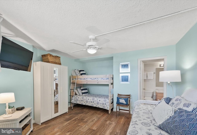 bedroom featuring ensuite bath, a textured ceiling, ceiling fan, and dark hardwood / wood-style floors