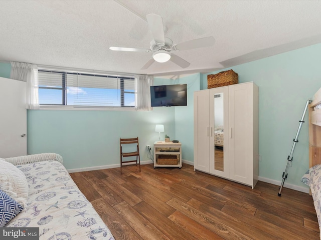 bedroom featuring a textured ceiling, ceiling fan, and dark hardwood / wood-style floors