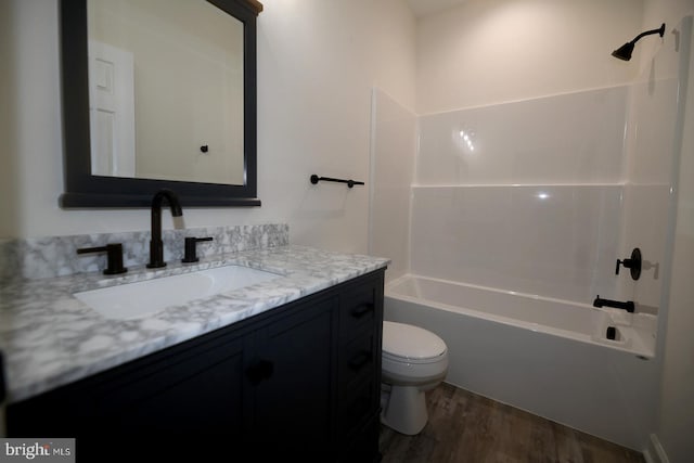 full bath featuring wood finished floors, tub / shower combination, vanity, and toilet
