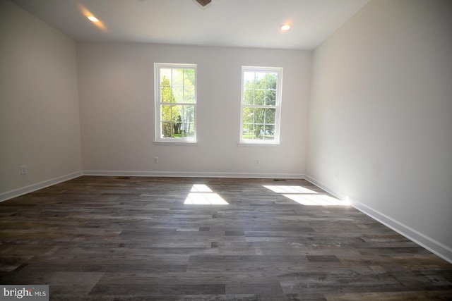 unfurnished room with dark wood-type flooring, baseboards, and recessed lighting