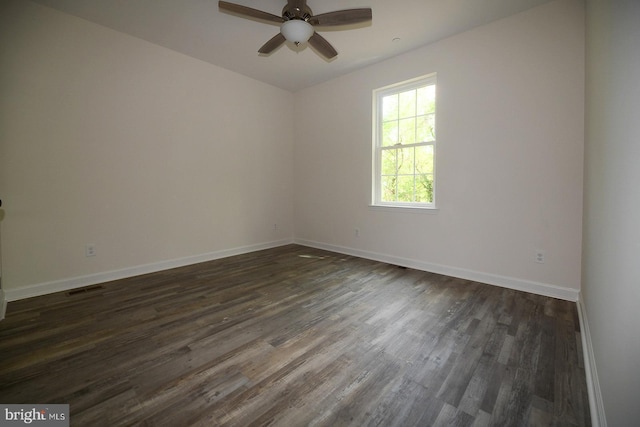 unfurnished room featuring dark wood finished floors, visible vents, a ceiling fan, and baseboards