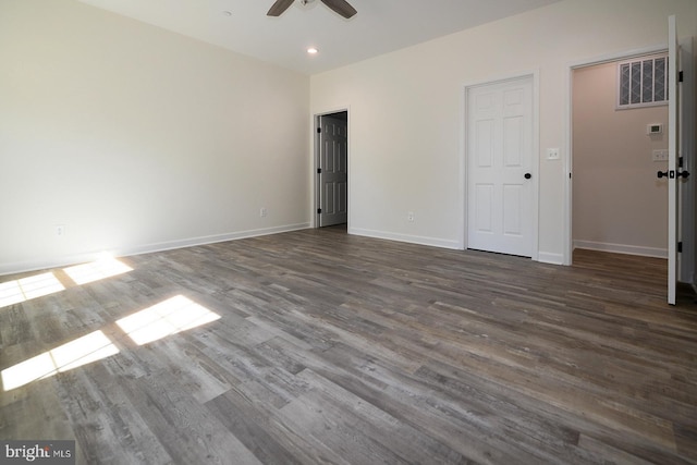 unfurnished bedroom featuring visible vents, baseboards, and dark wood-type flooring