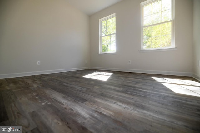 unfurnished room with lofted ceiling, baseboards, and dark wood-type flooring