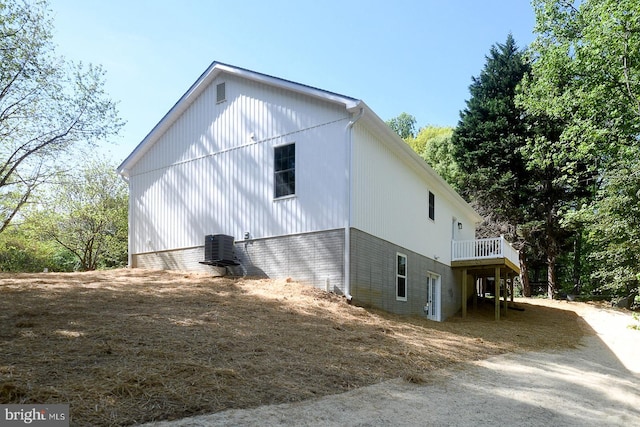 view of property exterior with cooling unit and a wooden deck