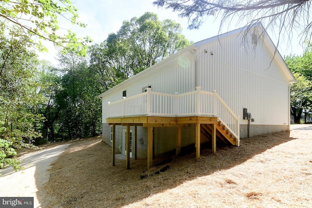 rear view of property featuring stairway and a deck