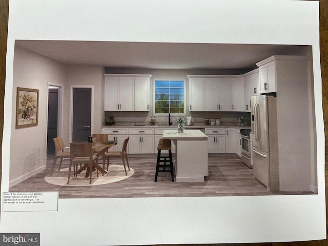 kitchen featuring white cabinetry, appliances with stainless steel finishes, a center island, and a kitchen bar