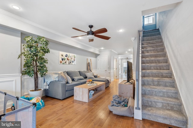 living room with ceiling fan, hardwood / wood-style flooring, and crown molding