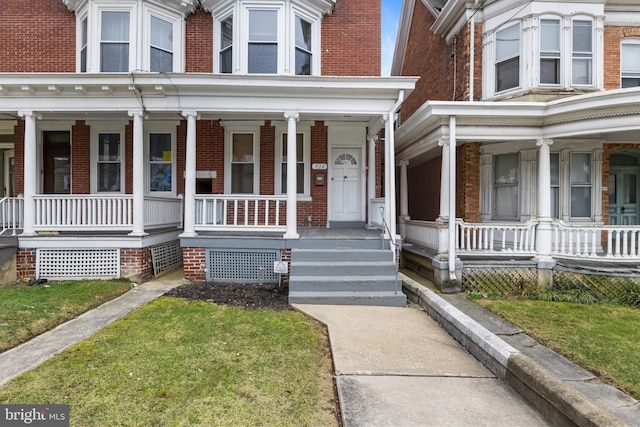 view of front facade with covered porch and brick siding