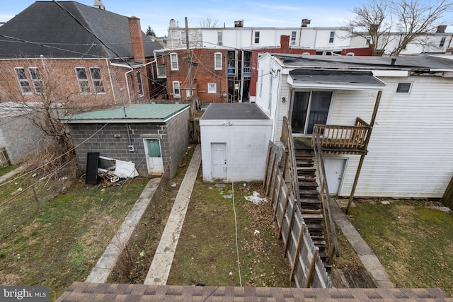 back of property with an outbuilding, stairway, and a residential view