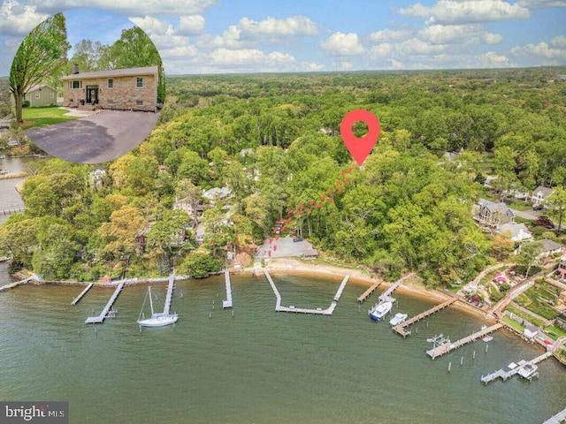 aerial view with a water view and a wooded view