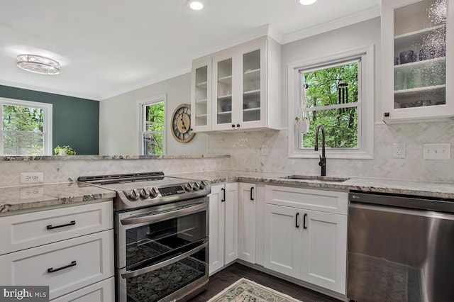kitchen featuring white cabinets, a wealth of natural light, appliances with stainless steel finishes, and a sink