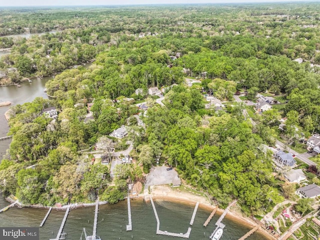 bird's eye view featuring a wooded view, a residential view, and a water view