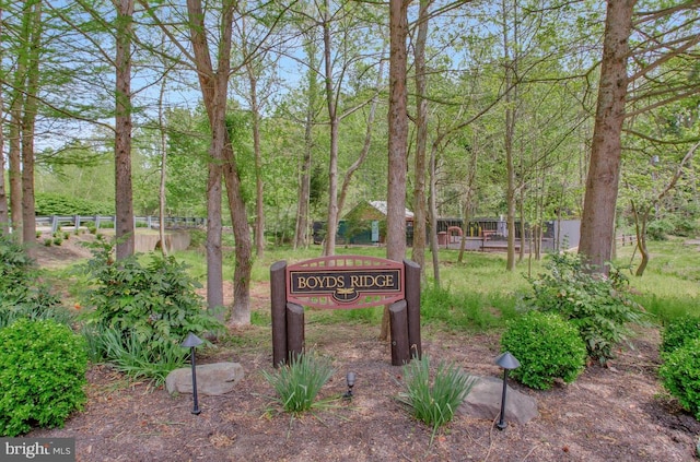 community / neighborhood sign featuring fence